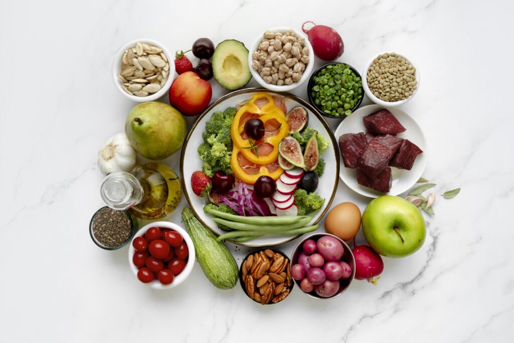 "Vibrant array of traditional Indian gut-health foods: turmeric, cumin, fennel seeds, fresh ginger, and a bowl of probiotic-rich dahi (yogurt) with herbs, alongside fiber-packed lentils and fermented idli."