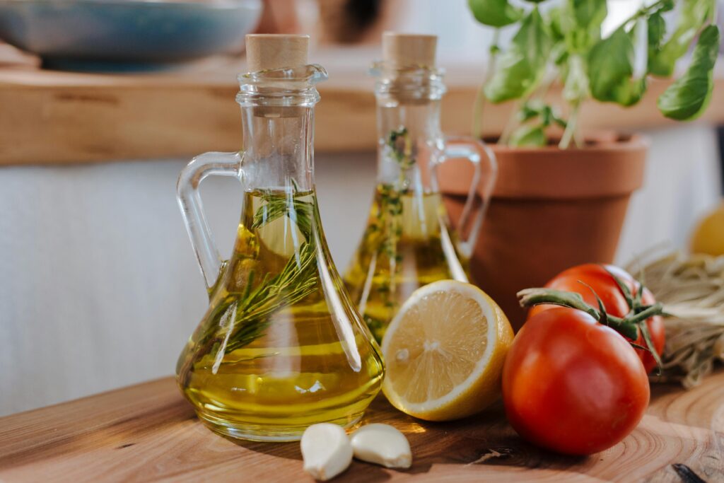Golden olive pomace oil in a clear glass bottle drizzling into a pan, showcasing its versatility for high-heat cooking. Discover the benefits of this heart-healthy kitchen staple
